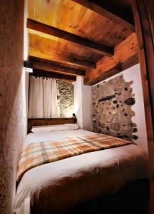 Bett in einem Zimmer mit Holzdecke in der Unterkunft Apartamento Gerbille in Bourg-Madame