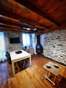 ein Wohnzimmer mit einem Tisch und einer Steinmauer in der Unterkunft Apartamento Gerbille in Bourg-Madame