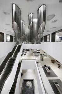 a lobby with stairs and chandeliers in a building at Aeonic Suites and Spa in Mýkonos City