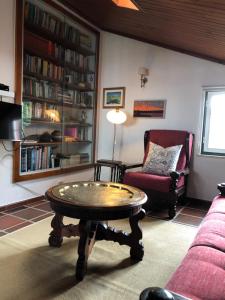 sala de estar con mesa de centro y silla en Casas Dos Infantes - Turismo Rural, en Caldas da Rainha