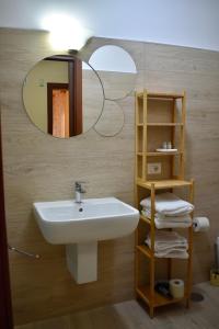 La salle de bains est pourvue d'un lavabo et d'un miroir. dans l'établissement Dimora normanna, à Aversa