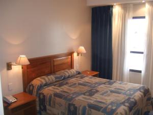 ein Hotelzimmer mit einem Bett und einem Fenster in der Unterkunft HOTEL SANTA CRUZ in Río Gallegos