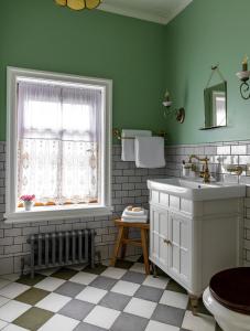a green bathroom with a sink and a window at Бутик-отель Пестово подворье in Suzdal