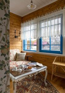 a room with a bed and a table and windows at Бутик-отель Пестово подворье in Suzdal