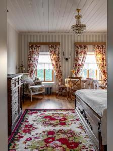 a bedroom with a bed and a table and windows at Бутик-отель Пестово подворье in Suzdal