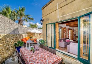 d'une terrasse avec une table et un canapé. dans l'établissement Casetta Menzja Semi Detached Bungalow, à Sannat