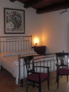 1 dormitorio con 1 cama, 2 sillas y mesa en Turismo Rurale Cefalù en Cefalù