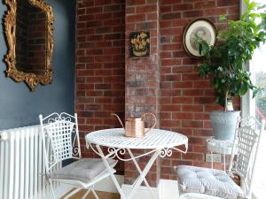 a patio with a table and chairs and a brick wall at The Rector's Retreat at the Old Vicarage in Lincoln