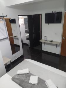 um quarto com um espelho e duas toalhas em Hotel Aura Medellin em Medellín