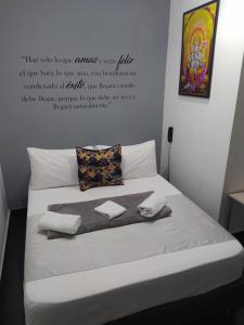 a bed with a quote on the wall at Hotel Aura Medellin in Medellín