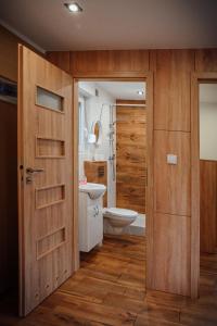 een badkamer met een toilet, een wastafel en een deur bij Domek letniskowy SZWED-POL in Kujan