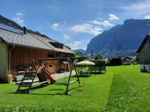 einen Hof mit Schaukeln und Tischen und ein Haus in der Unterkunft Haus Dekker in Mellau