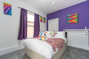 Schlafzimmer mit lila Wänden und einem Bett in der Unterkunft Mercy Way 4 Bedroom-6 Beds-Central Hull-Sleeps 8 in Hull