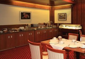 ein Esszimmer mit Tisch und Stühlen und eine Küche in der Unterkunft Hotel Seegarten Quickborn in Quickborn