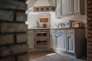 a kitchen with stainless steel appliances and a brick wall at The Old Hall Inn in Chinley