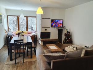 a living room with a table and a christmas tree at Zeleni svet 2 in Crni Vrh