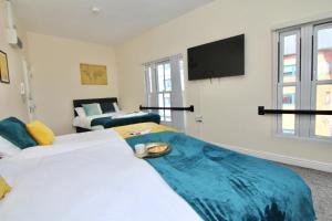 a bedroom with two beds and a flat screen tv at Elegant Studio 5 mins Walk to Coventry Transport Museum in Coventry