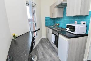 a small kitchen with a black counter top at Elegant Studio 5 mins Walk to Coventry Transport Museum in Coventry