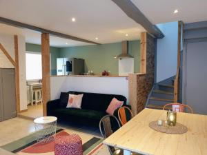 uma sala de estar com um sofá e uma mesa em Agréable Maison de 72m2, avec terrasse privée em Boeil-Bezing