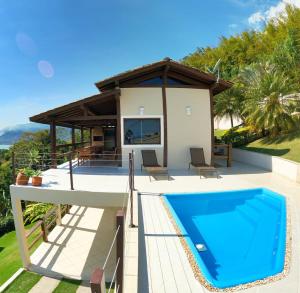 uma villa com uma piscina e uma casa em Vista espetacular, churrasqueira gourmet e piscina aquecida em Ilhabela