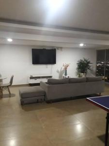 a living room with a couch and a tv at 2 room department (5 people). Private exclusive area in Guayaquil in Guayaquil