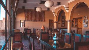 a dining room with tables and chairs in a building at L'oasis Du Bonheur in Aït Benhaddou