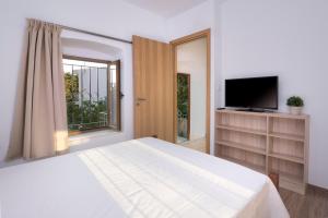 PylíonにあるTraditional Villa Stergiaの白いベッドルーム(大型ベッド1台、テレビ付)