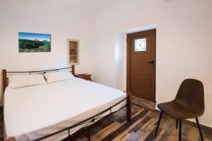 ein Schlafzimmer mit einem Bett und einem Stuhl in der Unterkunft Traditional Villa Stergia in Pylíon