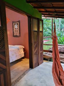 a room with a bed and a hammock in it at Casa Mestiça in Ilha de Boipeba