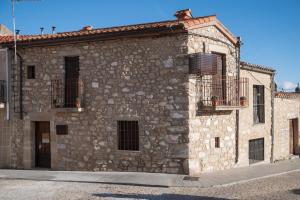 un edificio de piedra con 2 balcones en una calle en El Postigo en Trujillo