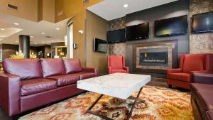uma sala de estar com sofás e uma lareira em Best Western Premier Freeport Inn Calgary Airport em Calgary