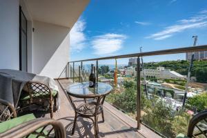 敖德萨Arcadia Sky квартира возле моря的阳台配有玻璃桌和一瓶葡萄酒