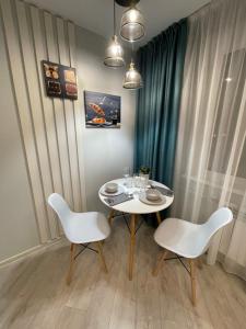 a dining room with a white table and two chairs at Krivenko 49 Str by Slissenko Inn in Pavlodar