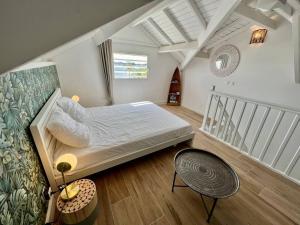 a bedroom with a large bed and a staircase at Duplex JUNGLE BLEUE Terrasse vue mer incroyable in Marigot
