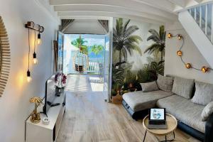 een woonkamer met een bank en een tafel bij Duplex JUNGLE BLEUE Terrasse vue mer incroyable in Marigot