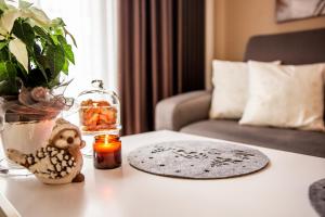 - une table avec une bougie et un vase dans l'établissement Apartament Bimba & Free Parking, à Poznań