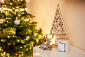 un sapin de Noël et une bougie sur une table à côté d'une décoration de Noël dans l'établissement Apartament Bimba & Free Parking, à Poznań