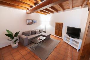 sala de estar con sofá y TV en El Postigo en Trujillo