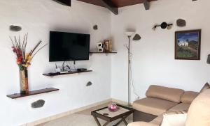 ein Wohnzimmer mit einem Sofa und einem Flachbild-TV in der Unterkunft Sun, Relax & Lava, Free wifi 600mb, BBQ in Tinajo
