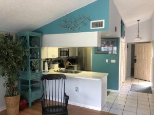 uma cozinha com paredes azuis e brancas e uma cadeira em Florida Condos on Lake Tarpon em Palm Harbor