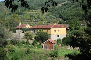 a group of houses on a hill with trees at Quinta dos Mouras in Celorico de Basto