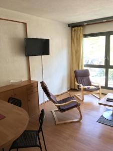 a living room with chairs and a table and a television at La Mongie, apt 30m2 centre station in Bagnères-de-Bigorre