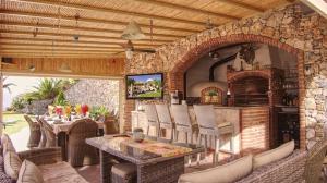 d'une terrasse avec une table et un mur en pierre. dans l'établissement Exceptional Costa del Sol villa for 8, Hi spec, Tranquil setting, Amazing views. Heated pool., à Torrox