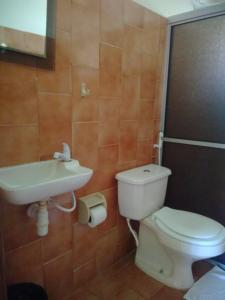 a bathroom with a toilet and a sink at Pousada Aldeia Mar in Ilhéus