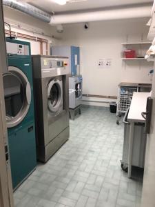 a laundry room with a washing machine and a washer at Avanti Apartment Hotel in Stockholm