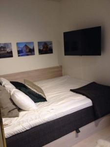 a bedroom with a large white bed with a flat screen tv at Avanti Apartment Hotel in Stockholm