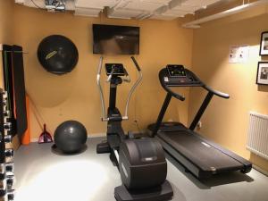 a room with a gym with a treadmill and a television at Avanti Apartment Hotel in Stockholm