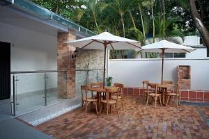 a group of tables and chairs with umbrellas on a patio at EL CIELO By Ruby in La Victoria