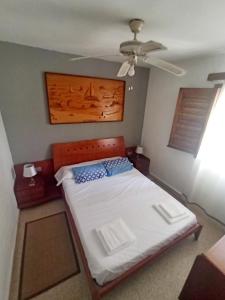 um quarto com uma cama e uma ventoinha de tecto em The Beach House Denia -- Casa en primera línea de playa - Denia em Denia