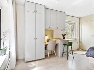 a bedroom with white cabinets and a desk with a chair at Avanti Apartment Hotel in Stockholm
